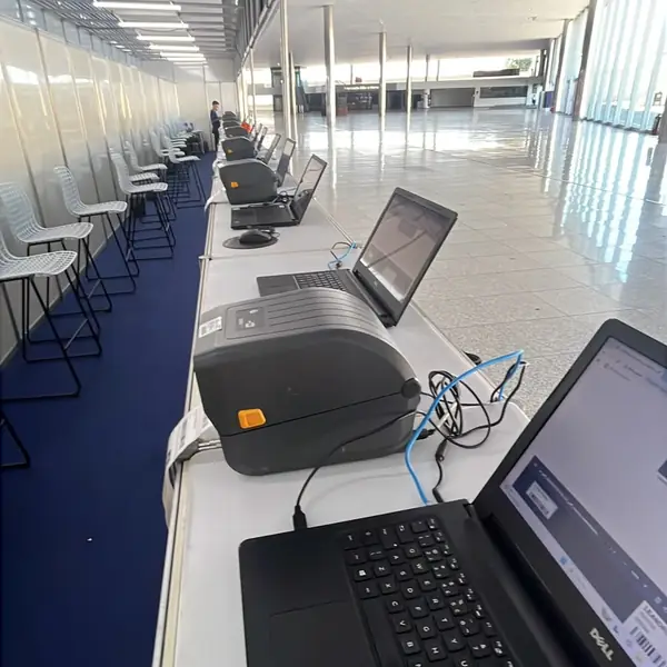 Fila de estações de credenciamento montadas ao longo do corredor do evento
